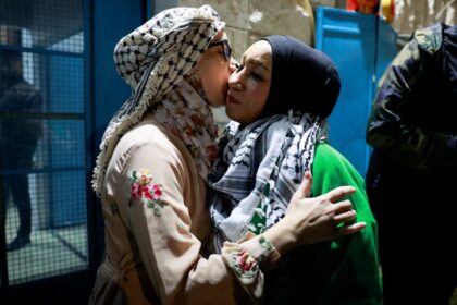 A released Palestinian prisoner kisses a loved one as she leaves the Israeli military prison